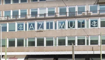 Facciata della sede di Azimut a Milano con logo e scritta visibili sulle finestre.