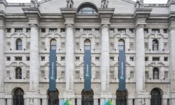 Facciata del Palazzo Mezzanotte, sede della Borsa Italiana a Piazza Affari a Milano, con colonne monumentali e bandiere Euronext.