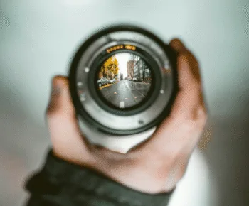 Obiettivo fotografico che mette a fuoco una strada cittadina, mentre il resto dell’immagine è sfocato.