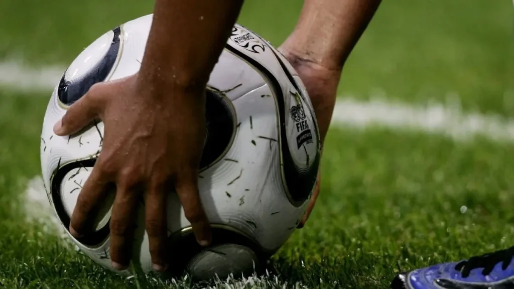 Un calciatore mette il pallone sul dischetto
