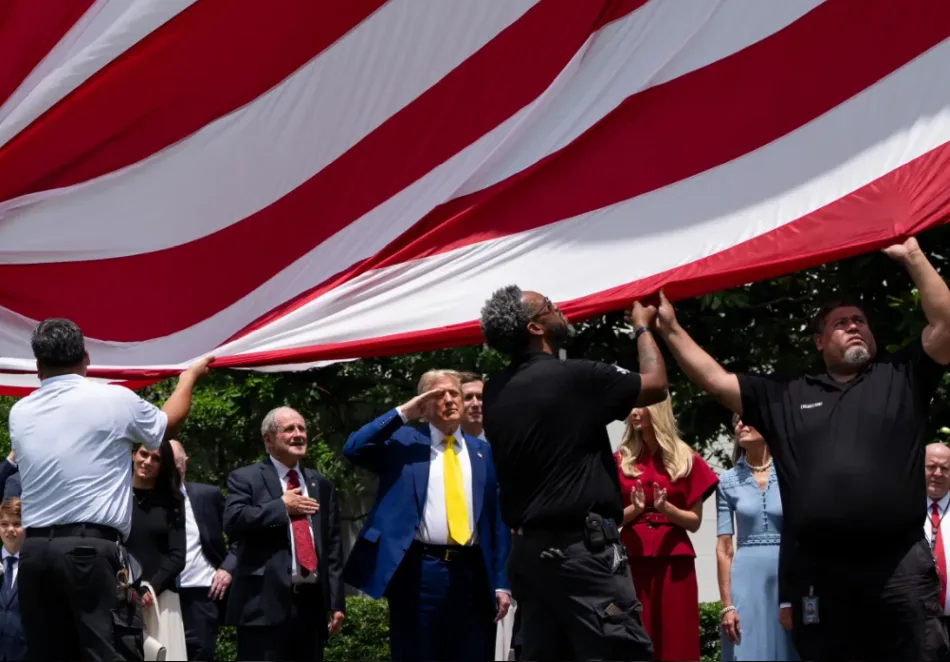II presidente degli Stati Uniti Donald Trump saluta la bandiera americana, nel giardino della Casa Bianca, circondato sai suoi collaboratori