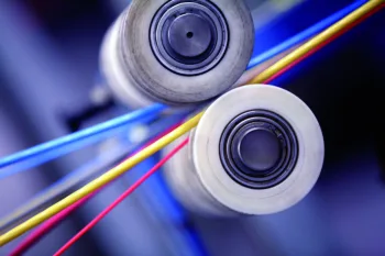 Primo piano su rulli industriali per l’estrusione di cavi elettrici multicolore in un impianto produttivo Prysmian