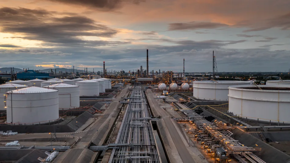 Impianto petrolifero con serbatoi di stoccaggio e oleodotti al tramonto, terminal industriale