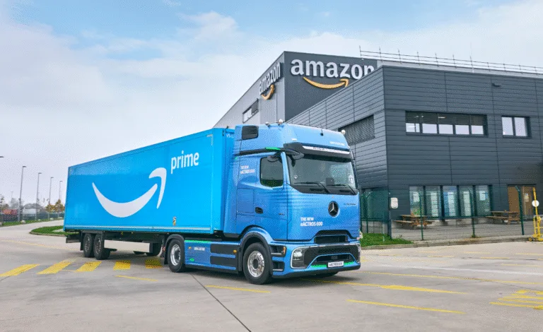 Camion elettrico Amazon Prime eActros 600 davanti a centro logistico Amazon.