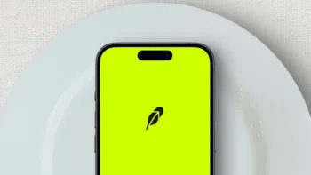 Uno smartphone con l'app di Robinhood poggiato su un piatto