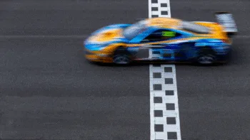 Auto da corsa sfocata in movimento su una linea del traguardo
