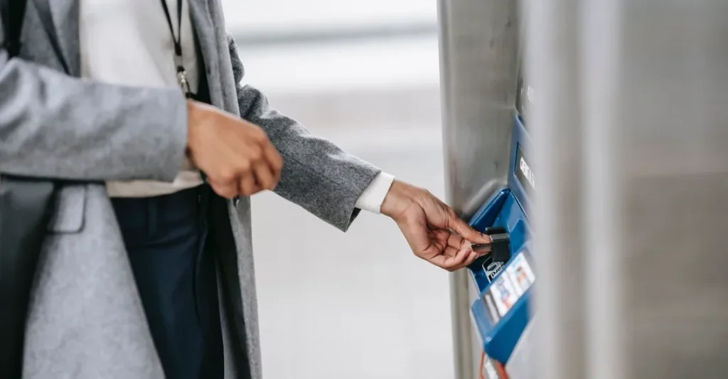 Un uomo effettua un'operazione bancaria inserendo la sua carta in uno sportello ATM.