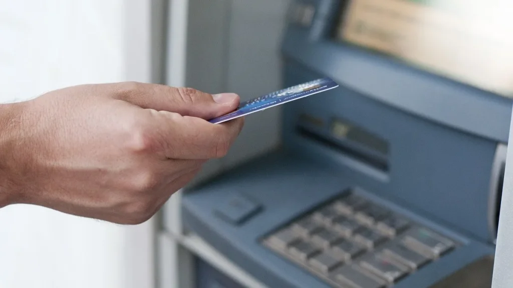 Un cliente all'Atm di uno sportello bancario