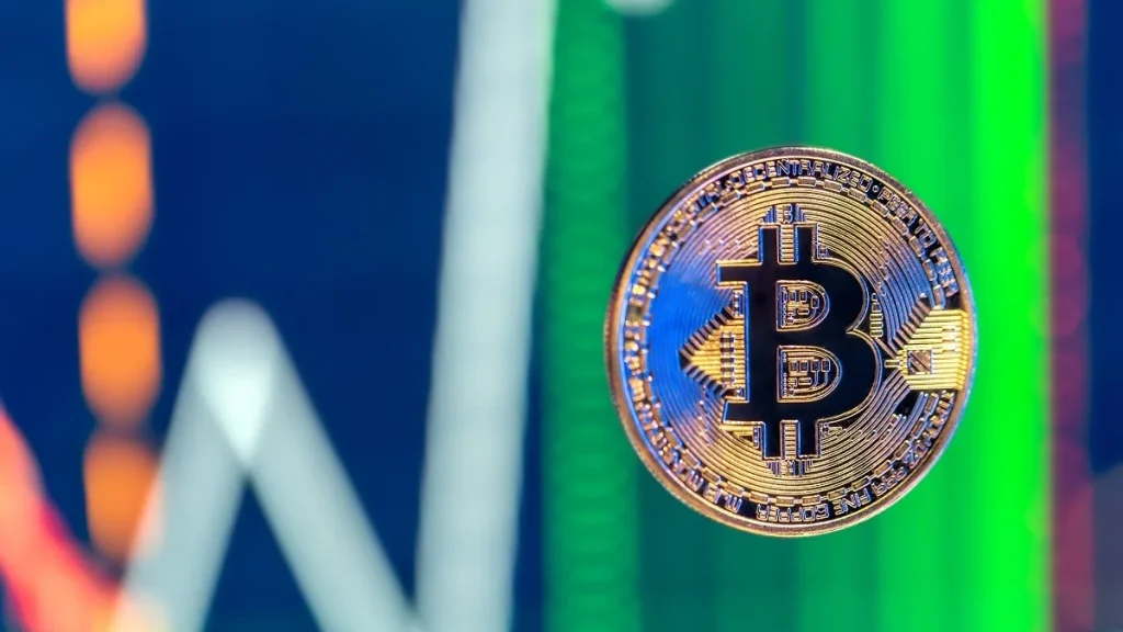 Un token Bitcoin con un grafico di trading sullo sfondo