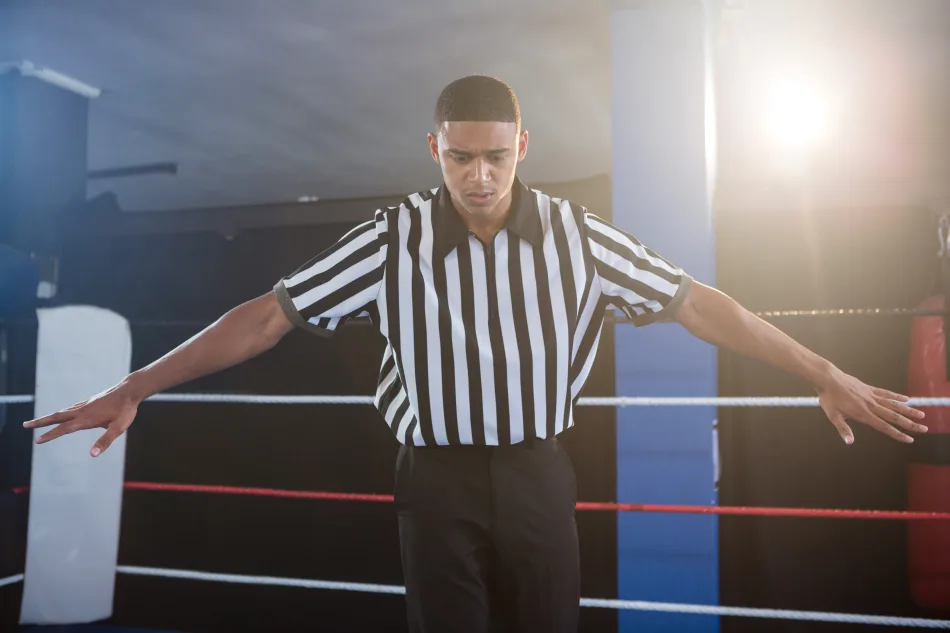 Un arbitro di boxe su un ring mette fine a un incontro