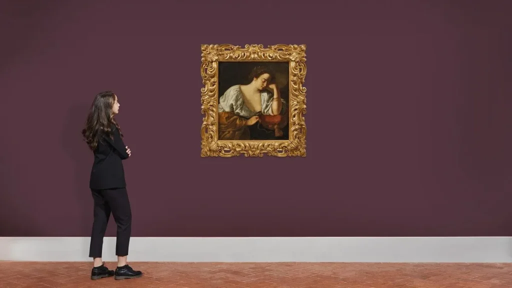 Una donna ammira il dipinto Cleopatra di Artemisia Gentileschi