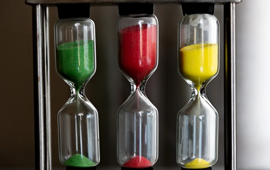 Tre clessidre contenenti sabbia verde, rossa e gialla.