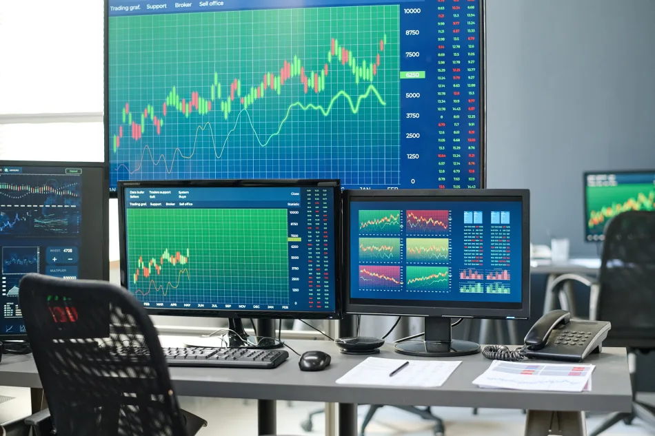 Schermi di pc che mostrano grafici e statistiche sull'andamento dei mercati finanziari