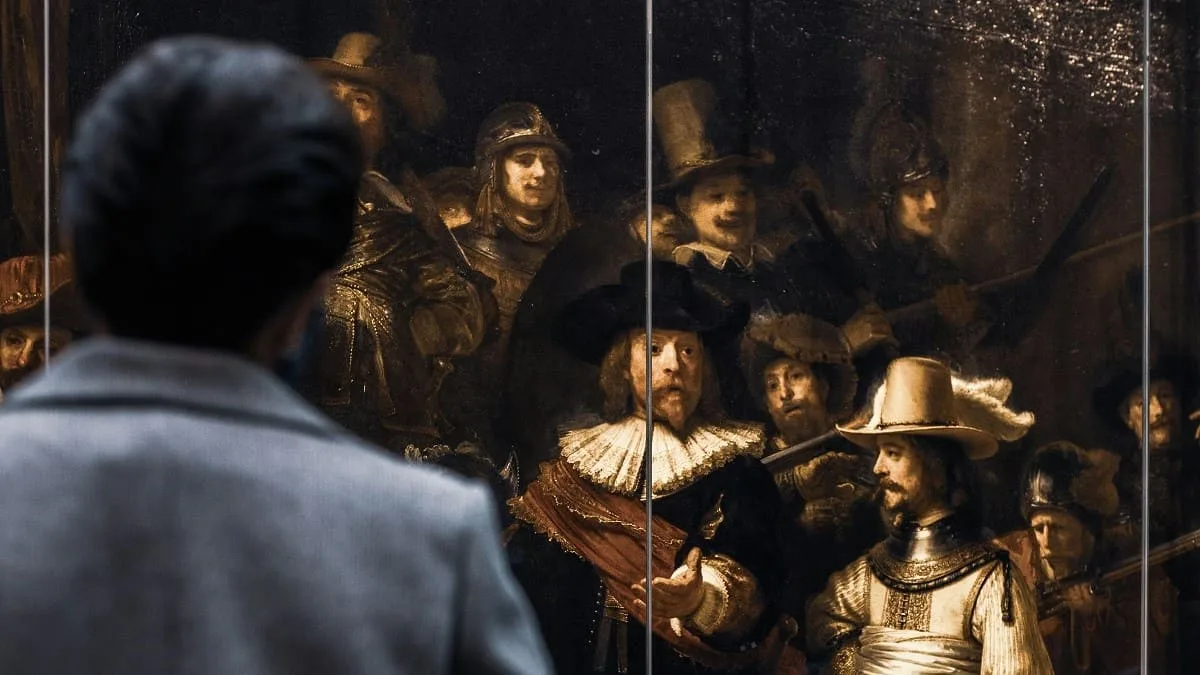 Un uomo ammira un dipinto di Rembrandt
