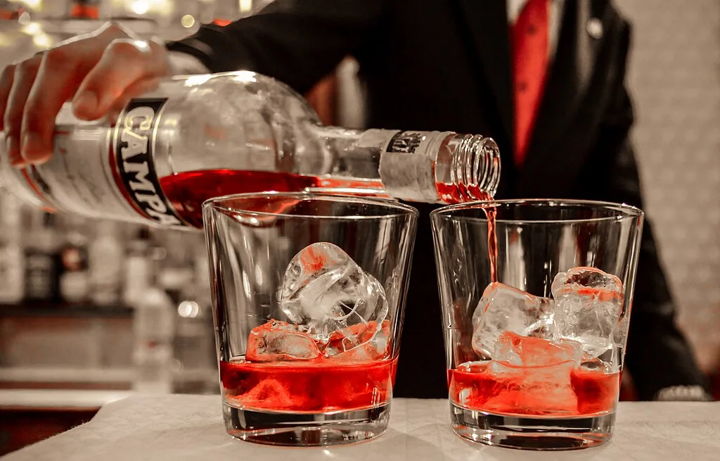 Al caffé Florian di Venezia, un cameriere riempie ue bicchieri con il Campari