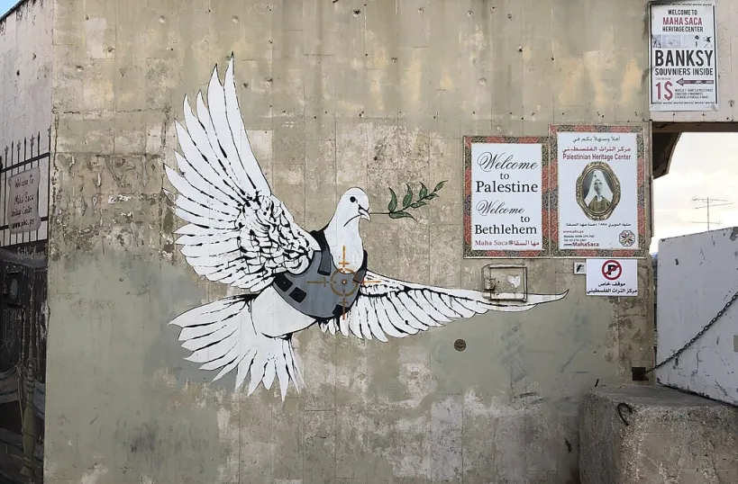 Colomba della pace a Betlemme. Opera di Banksy fotografata da Davide Mauro. On Wikimedia. Licenza: https://creativecommons.org/licenses/by-sa/4.0/deed.en. Originale al link: https://commons.wikimedia.org/wiki/File:Peace_dove_by_Banksy_in_Bethlehem.jpg.