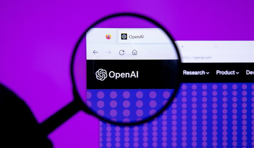 Una lente di ingrandimento inquadra il logo di OpenAI nella pagina internet del bot su uno schermo di pc
