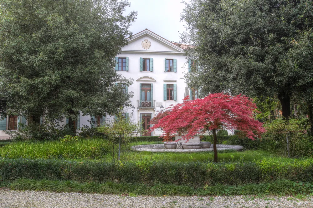 Villa Furstenberg sullo sfondo di un giardino fiorito. È la sede di Banca Ifis