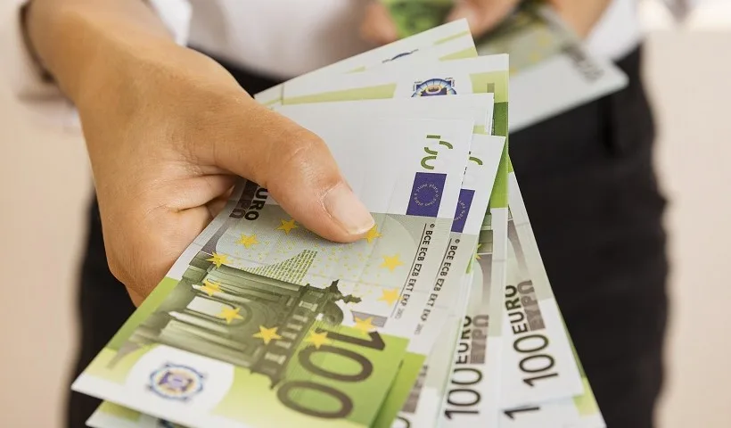 Una persona porge banconote da 100 euro di un salario