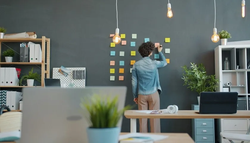 Il founder di una startup sistema note adesive su una parete