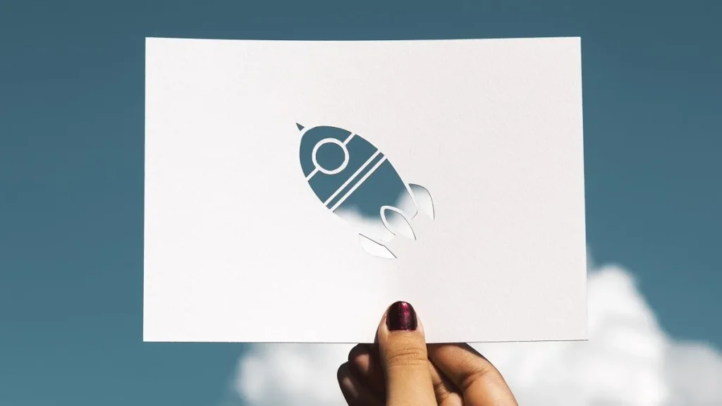 Una donna tiene in mano la stampa di un razzo simbolo del lancio di una startup