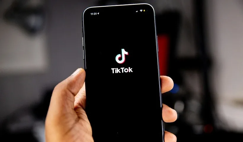 Una persona tiene in mano uno smartphone con l'app di TikTok