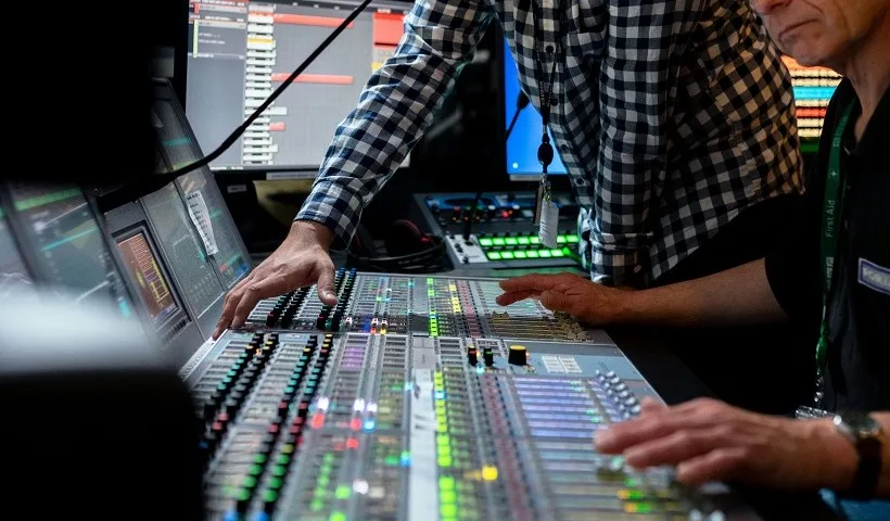 Due persone al mixer in uno studio di registrazione