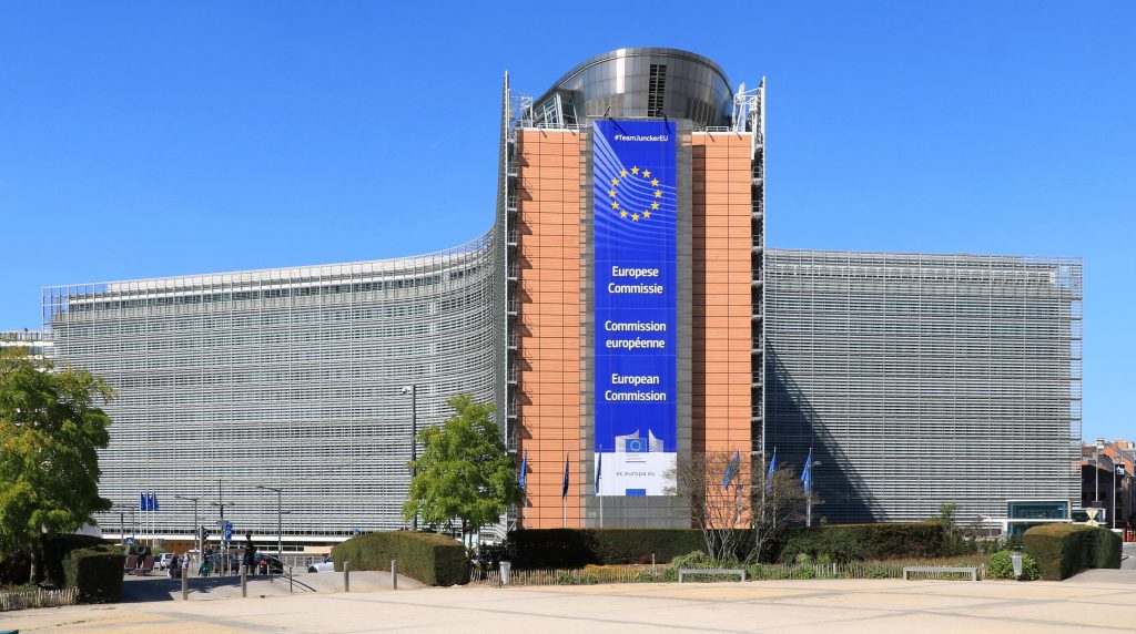Facciata del Palazzo Berlaymont a Bruxelles, sede della Commissione europea, con bandiere europee sullo sfondo