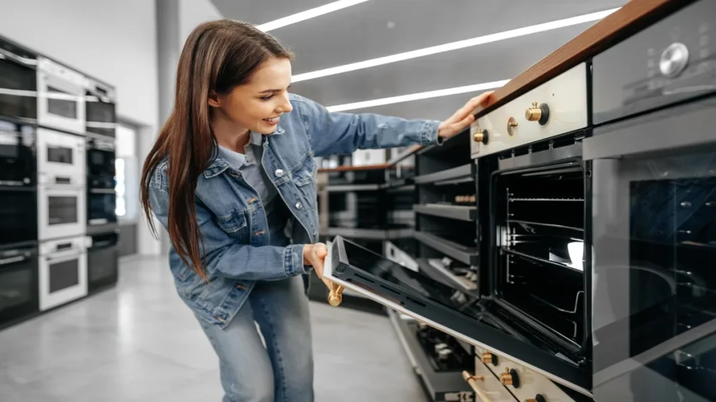 Donna che controlla un forno in negozio per l’acquisto di elettrodomestici
