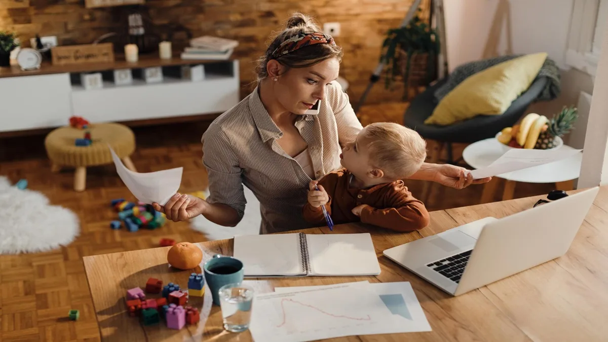 Mamma lavoratrice in smart working con il figlio piccolo, immagine rappresentativa del Bonus Mamme 2025