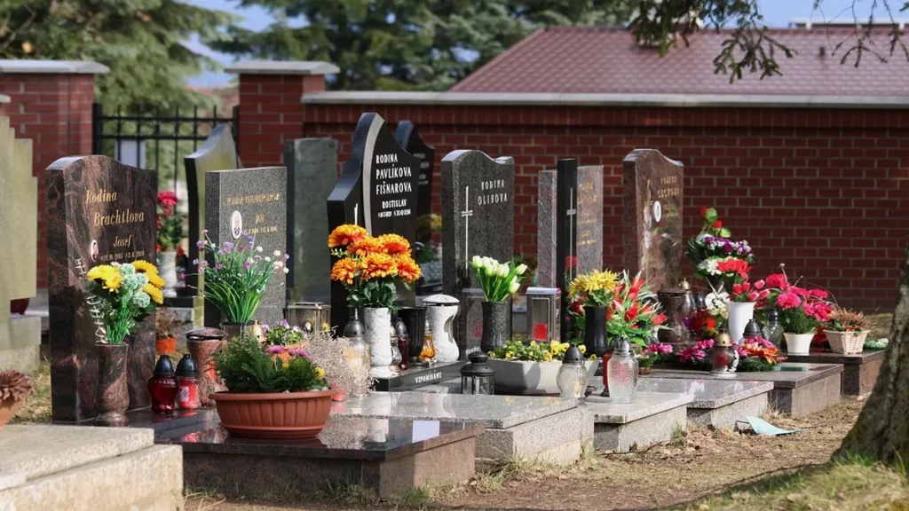Lapidi e tombe adornate con fiori in un cimitero, riferimento al Bonus Tombe 2026 e alla detrazione del 36% prevista dalla nuova Manovra