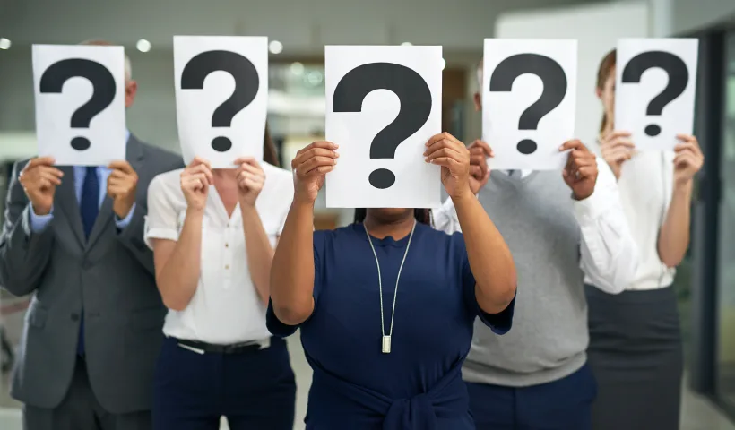 Un gruppo di cinque persone, donne e uomini, tengono davanti al visto un cartello con un punto interrogativo, a indicare l'insicurezza negli investimenti