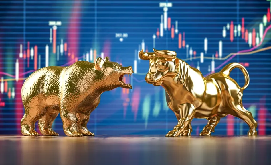 Due statuette dorate, un orso a sinistra e un toro a destra, si fronteggiano. Sullo sfondo un grafico a candele indica l'andamento dei mercati azionari