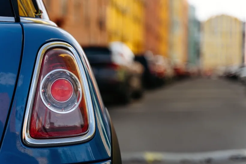 Retro di un’auto parcheggiata in città con sfondo sfocato, immagine per articolo su assicurazione auto e rincari 2026