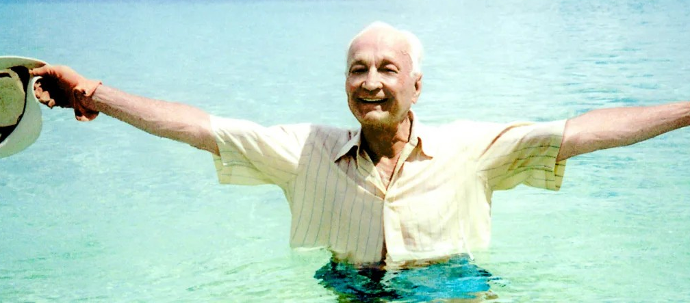 Immagine di John Templeton in acqua che allarga le braccia