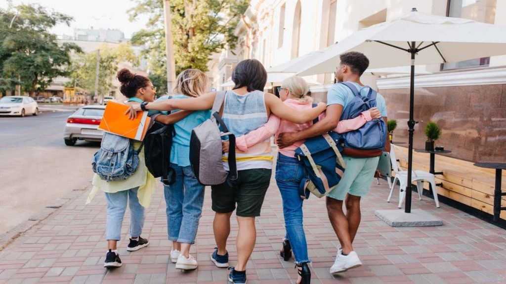 Studenti con zaini insieme all’esterno di una scuola, simbolo del bonus scuole paritarie 2026.