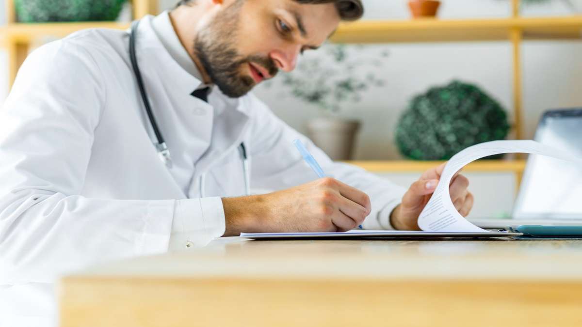 Medico che compila documenti per esenzione ticket sanitario 2026.
