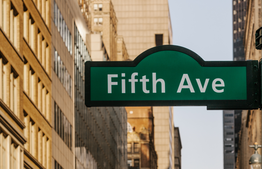 Il cartello posto all'inizio della Fifth Avenue a New York, lascia intravvedere alcuni palazzi sullo sfondo