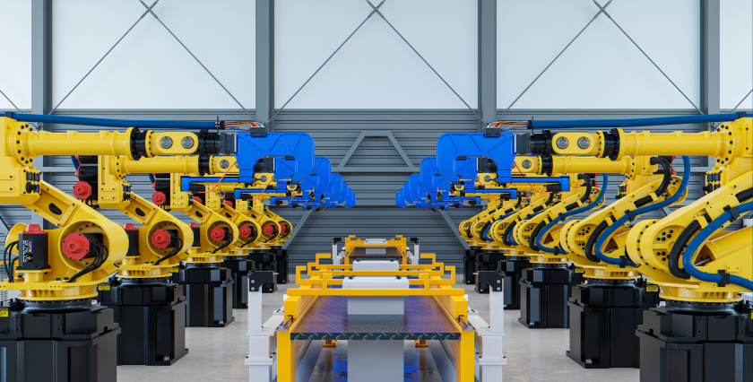 Una serie di bracci meccanici robotici allineati su una catena di montaggio di una fabbrica completamente automatizzata