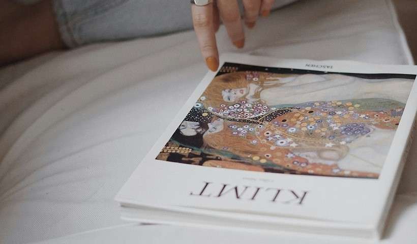 Una donna sfoglia un catalogo su Gustav Klimt