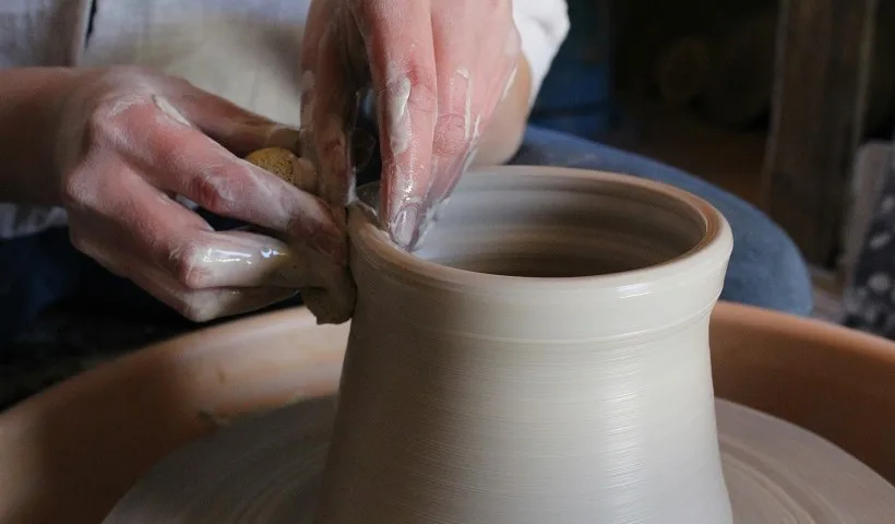 Un'artigiana realizza un vaso in terracotta