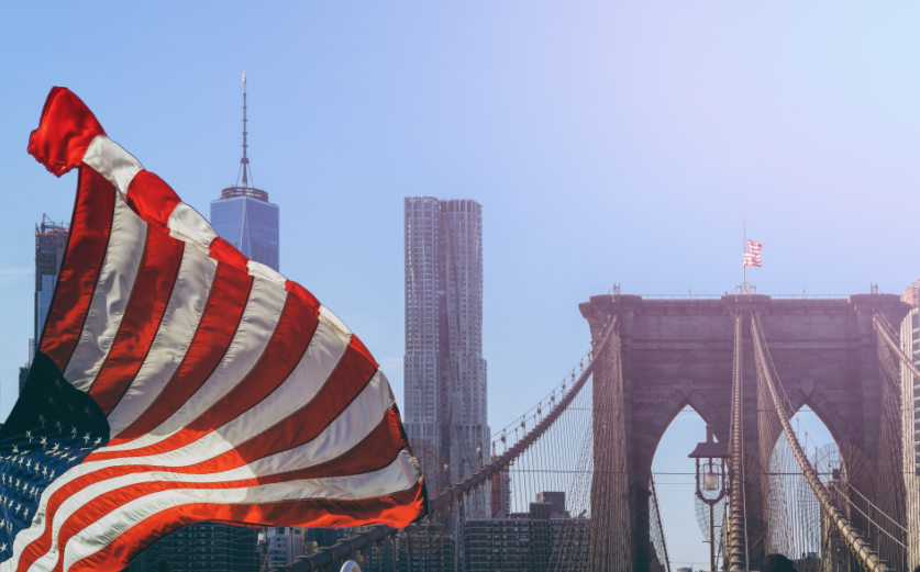 Una bandiera statunitense sventola davanti al ponte di Brooklin a New York.