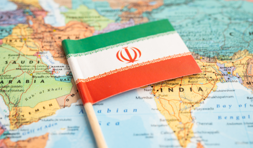 Una bandierina dell'Iran poggiata in corrispondenza del Paese su una mappa politica dove si vedono anche altre nazioni, tra le quali India, Arabia Saudita e Turchia