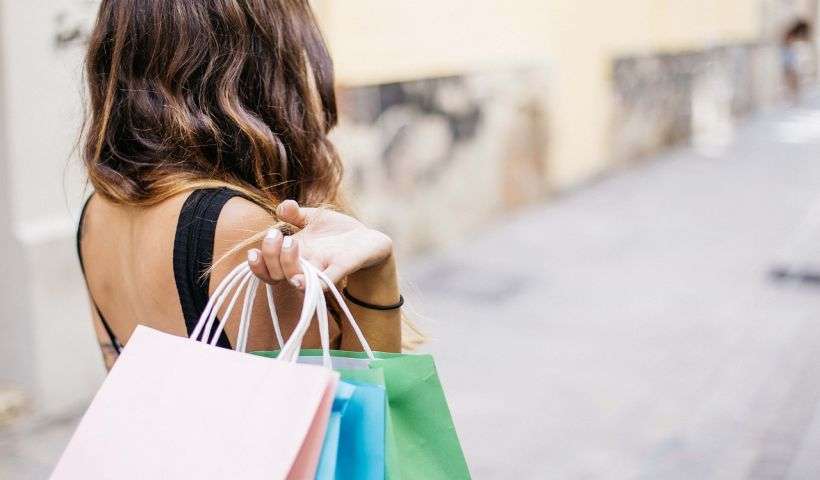 una donna che tiene tre pacchi dopo aver fatto shopping