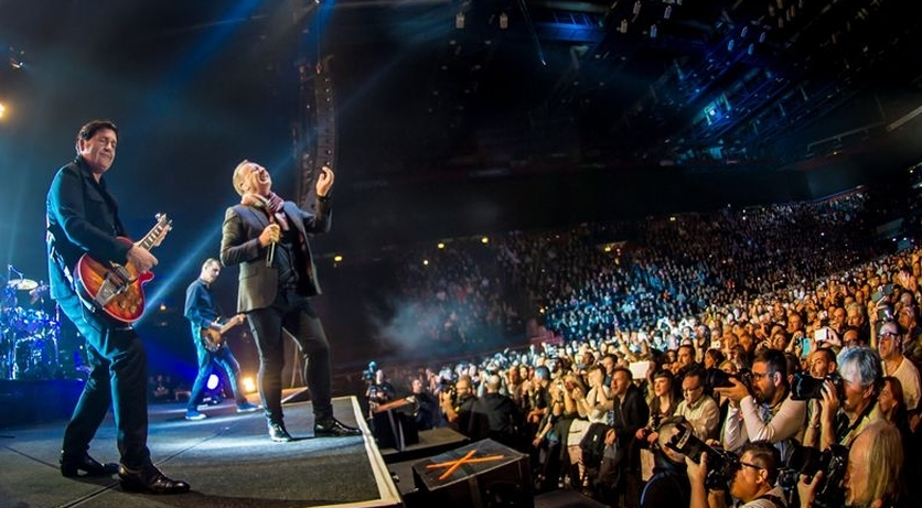 Un concerto dei Simple Mind al Forum di Assago. In prima fila alcuni giornalisti scattano delle foto, sulla sinistra il palco