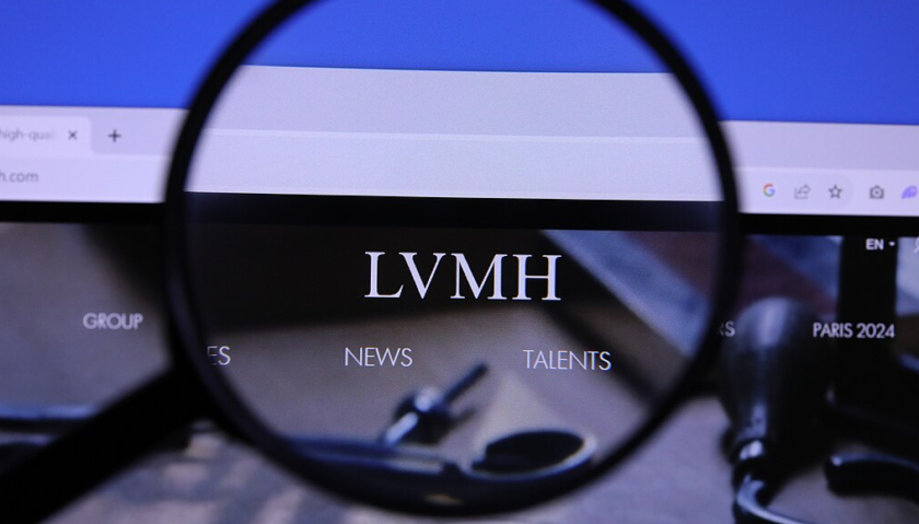 Una lente di ingrandimento ingrandisce, sullo schermo di un computer, il logo della casa di moda Lvmh