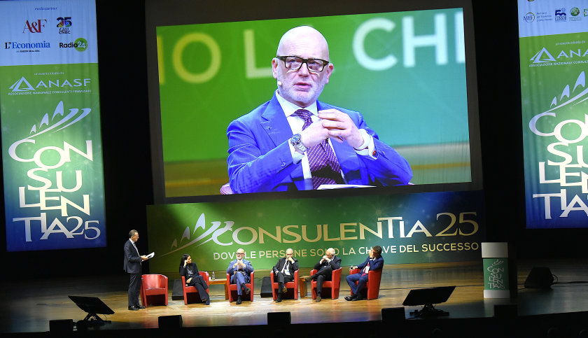 Il presidente di Anasf, Luigi Conte, in primo piano nello schermo che sovrasta il palco nel quale è in corso una tavola rotonda con vari invistati a Consulentia 25