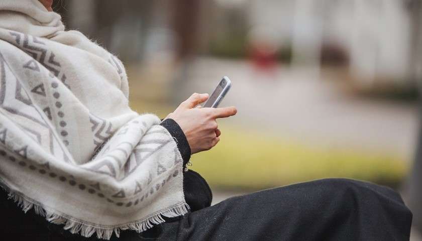 Una donna palestinese usa lo smartphone per una transazione digitale