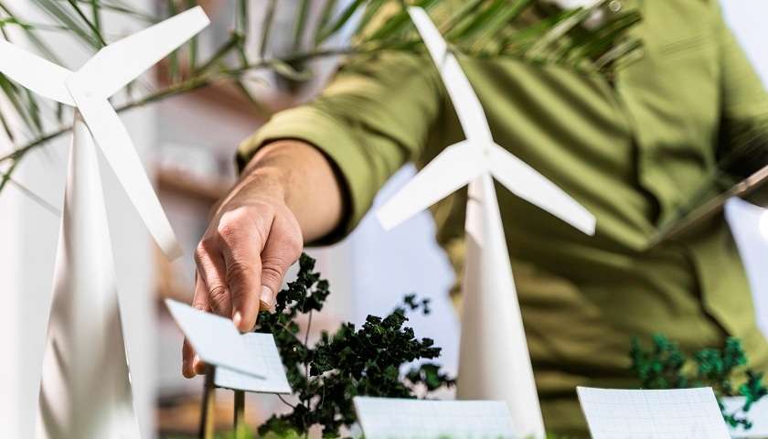 Una persona fissa un layout di progetto green di energia eolica