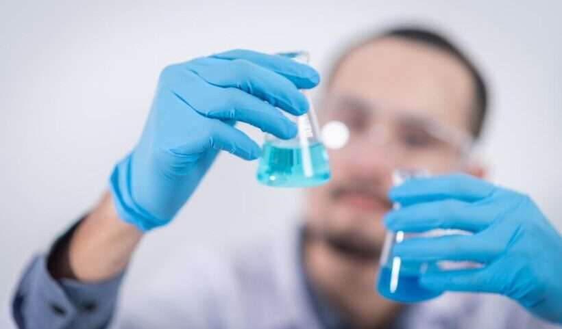 scienziato con boccette di vetro